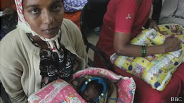 Mujer sostiene a un bebé envuelto en una manta