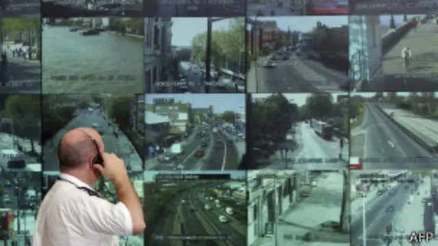 Un policía mira a un panel que recibe las imágenes de cámaras de seguridad