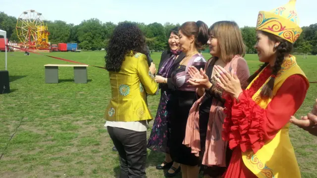 Уюштуруучулар элге өнөрүн тартуулаган журтташтарга белек ыйгарууда. 