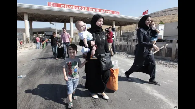 Сирийские беженцы пересекают турецкую границу. 