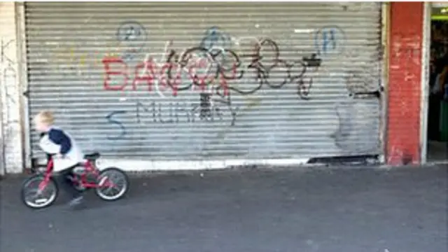 倒閉商店外的孩子