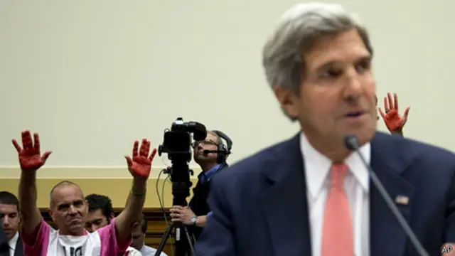Palmas rojas tras el secretario de Estado John Kerry, durante su comparecencia en el COngreso para explicar el caso de Siria