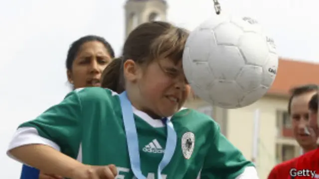 Niña pegándole a un balón