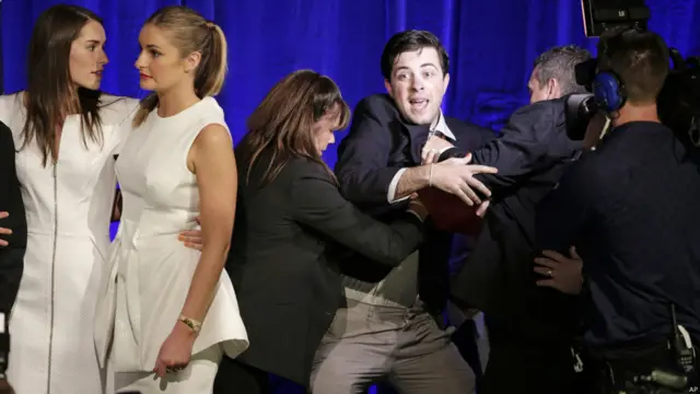 一名男子跟著阿博特的女兒混上講台，被保安人員趕下台。