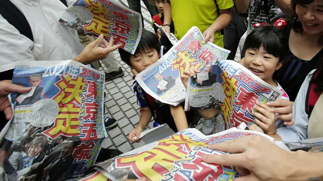 东京市民在街头领取报道申奥成功的报纸号外（8/9/2013）