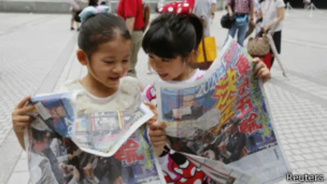 日本兒童在街頭閱讀慶祝東京申奧成功的報紙號外