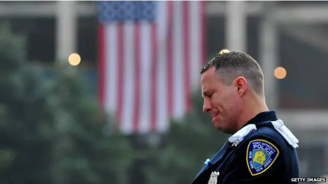 9/11 की घटना में मारे गए लोगों के लिए रखे गए मौन के दौरान एक पुलिसकर्मी.