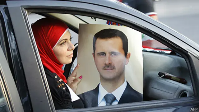 Simpatizante de presidente de Siria muestra un afiche en Damasco