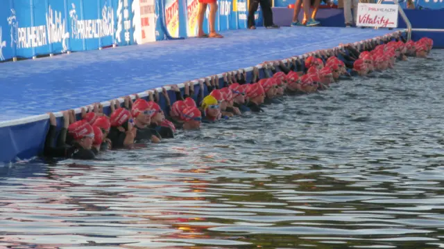 خانم گرامی که با پوششی متفاوت با سایر ورزشکاران وارد میدان شد با همکاری برگزارکنندگان خود را برای مرحله شنا آماده کرد