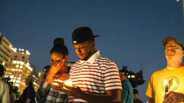 गोलीबारी में मारे गए लोगों के प्रति शोक जताते लोग