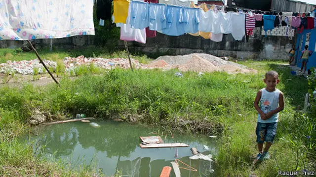 Hueco para una cisterna, inundado de agua, junto a un niño.