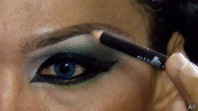 Una mujer pinta sus cejas. 