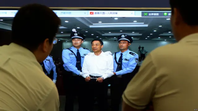 记者们在济南中院新闻中心内观看大屏幕上展示薄熙来被上手铐的照片（22/9/2013）