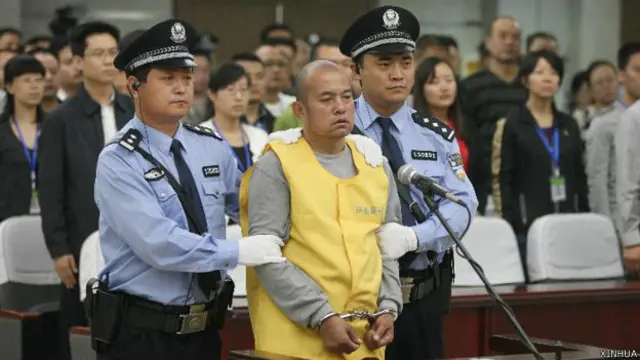 王书金（中）在邯郸市中级法院站立听判（新华社图片27/9/2013）