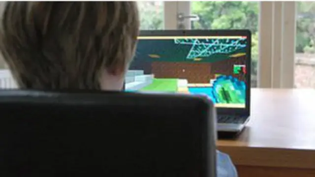 Niño viendo a una computadora