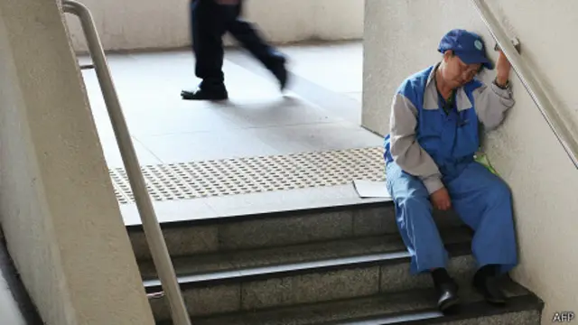 香港某人行天桥上一名环卫工人坐在楼梯边打盹(资料图片)