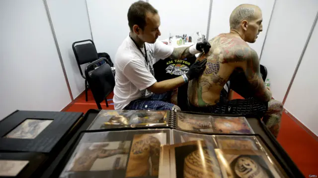 Manila'da Dünya Ticaret Merkezi'nde düzenlenen festivalde bir dövme sanatçısı ve dövme meraklısı.