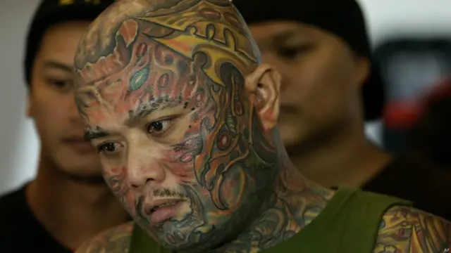 Tüm vücudu ve yüzü dövmeyle kaplı olan 37 yaşındaki Louie Linco bir arkadaşını dövme yaptırırken izliyor.
