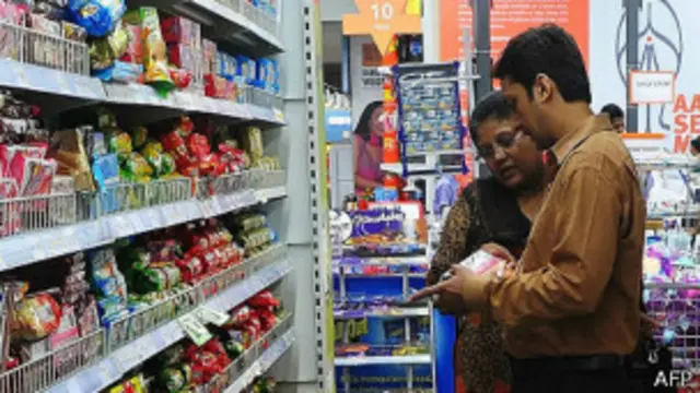 compradores revisan la etiqueta de productos en un supermercado