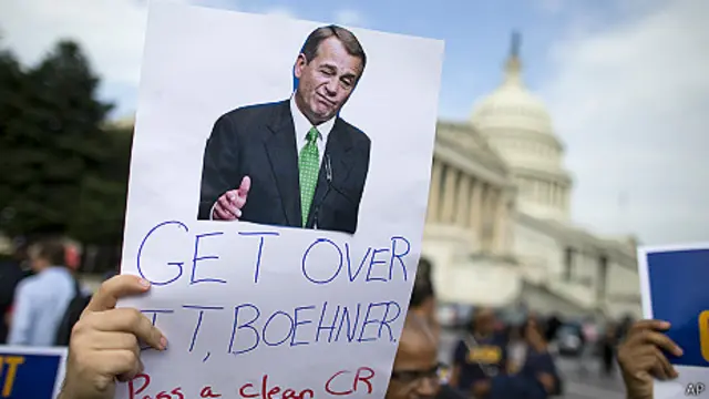 manifestante con cartel exige a Boehner aprobar prespuesto para el gobierno