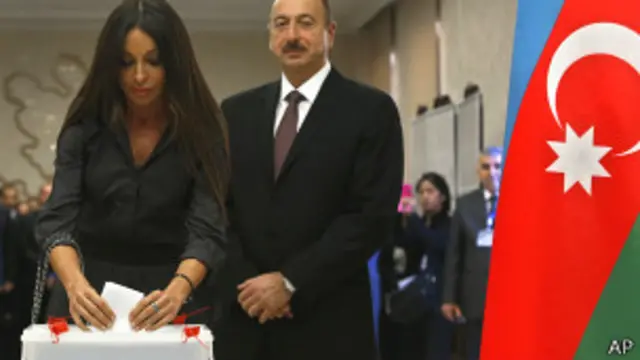 Ильхам Алиев смотрит, как его жена Мехрибан опускает бюллетень в урну