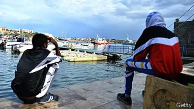 Выжившие мигранты на берегу Лампедузы