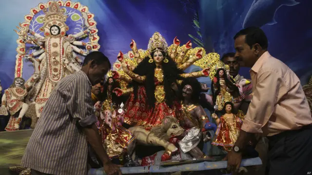 गुवाहटी में माँ दुर्गा की मूर्ति को स्थापित करने के लिए पंडाल में ले जाते लोग.माँ दुर्गा को शक्ति का स्वरूप माना जाता हे.