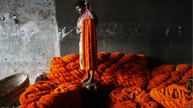 यह उत्सव बहुत से लोगों के लिए रोजगार का जरिया भी है. फूल बेचने के लिए अपनी दुकान को तैयार करता यह दुकानदार.