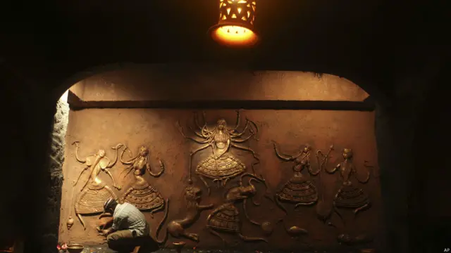 शक्ति की देवी माँ दुर्गा को अनेक नामों से पुकारा जाता है. उनका एक आकृति को अन्तिम रूप देता एक कलाकार.इस त्योहार को लेकर हर जगह एक अलग छटा देखने को मिल रही है. 