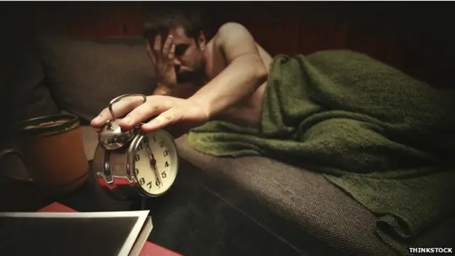 Hombre soñoliento y despertador