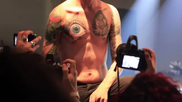 چوتھے بین الاقوامی ٹیٹو کنونشن میں ایک مرد اپنے جسم پر آنکھ کے ٹیٹو کی نمائش کر رہا ہے۔ 