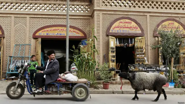 Қашғарлик мусулмон қурбонликка аталган қўйини уйига етакламоқда.