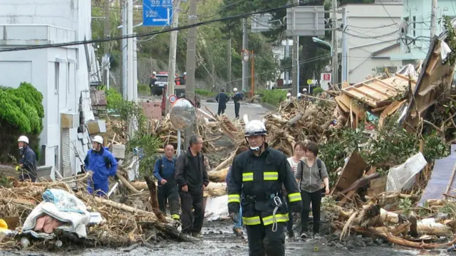 救援人员和居民走过大岛町一处泥石流灾区（16/10/2013）