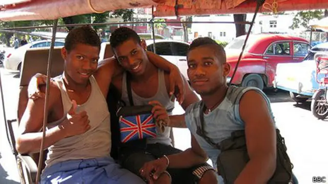 Jóvenes cubanos alardean de un bolso con la bandera británica