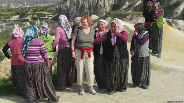 Begüm Karapınar, Kapadokya'da yerli kadınlarla bir turisti yan yana gülerken yakaladığı bu fotoğraf için "Kadın, emekçi, güzel, çalışkan, anamız, yarenimiz, bacımız her şeyimiz onlar. Hangi ülke ve kültürde olsa da kadın, kadındır." diyor.