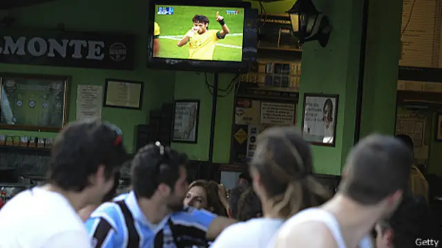 Clientes de bar ven partido de fútbol por TV