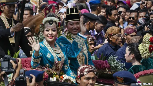 Warga berebut untuk menyaksikan kereta kerajaan melewati jalan di Yogyakarta. 