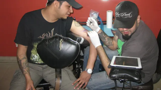 श्याम, लोकेश से अपने हाथ टैटू बनवा रहे हैं.