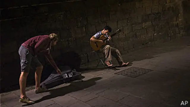 Álvaro Concha toca guitarra y vende discos en las calles de Barcelona