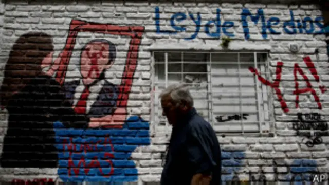 Homem passa ao lado de pichação em apoio ao governo argentino (foto: AP)