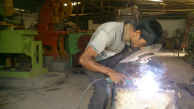 বগুড়ার একটি হালকা প্রকৌশল কারখানায় কাজ করছেন একজন শ্রমিক।