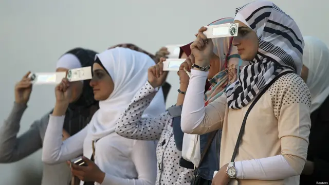 Mujeres aprecian el eclipse