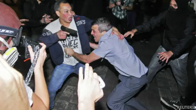 PM Reynaldo dos Santos sendo salvo por seu motorista armado de manifestantes. Foto: Reuters