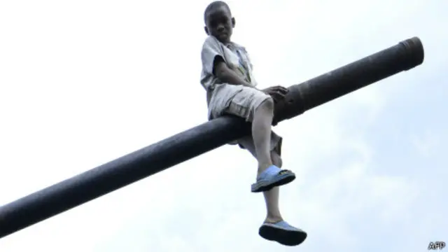 Criança brinca em tanque na República Democrática do Congo. Foto: AFP