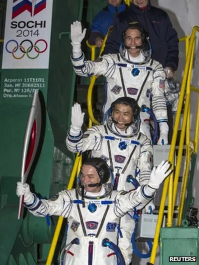 日本宇航员若田光一(上)、俄罗斯宇航员秋林(中)与美国宇航员马斯特拉基奥(下)手持索契冬季奥运火炬登上联盟号飞船(7/11/2013)