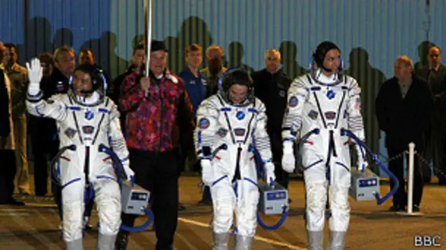 Космонавты на старте, позади - олимпийский факел