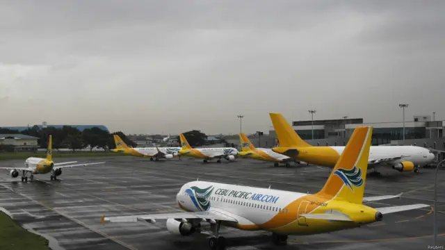 उड़ानें रद्द होने से मनीला के निनोय एक्विनो इंटरनेशनल एयरपोर्ट पर सीबो पेसिफ़िक एयरवेज़ के विमान खड़े हैं.