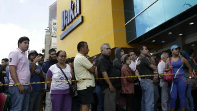 Clientes faxem fila ao lado de loja da rede Daka (foto: AP)