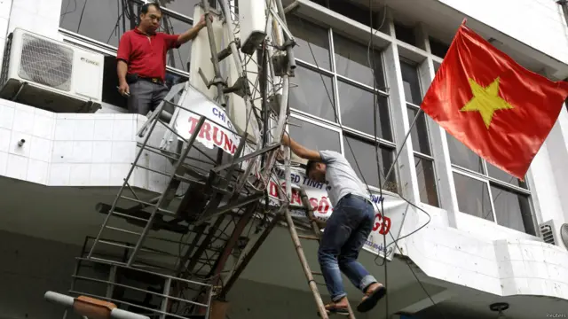 टीवी टॉवर की जांच करते कर्मचारी