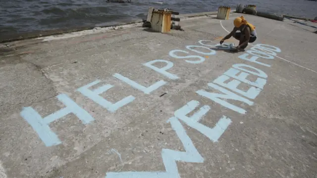 Un sobreviviente escribe un mensaje de socorro en el puerto